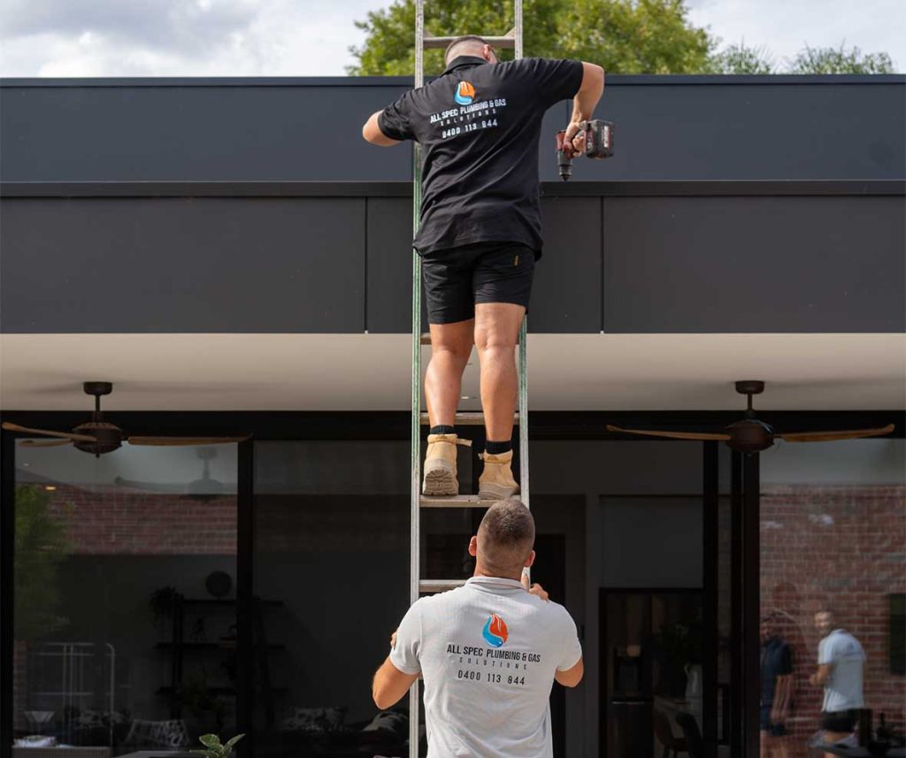 A roof plumber from All Spec inspecting and repairing a residential gutter system in the Eastern Suburbs Melbourne